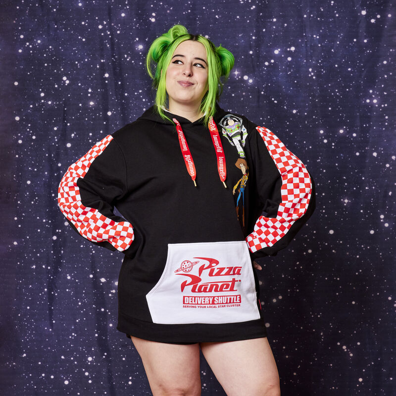 Woman wearing the Pizza Planet hoodie against a blue, starry background